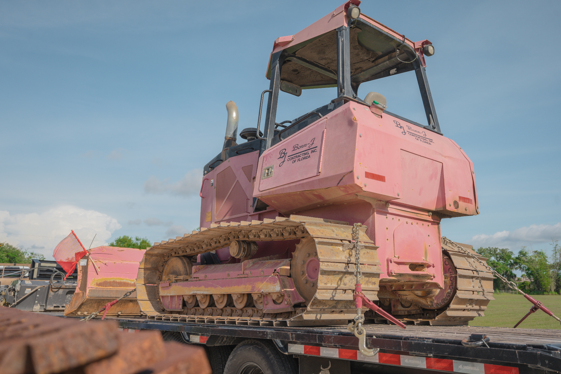 Pink Bonn-J bulldozer secured on flatbed trailer