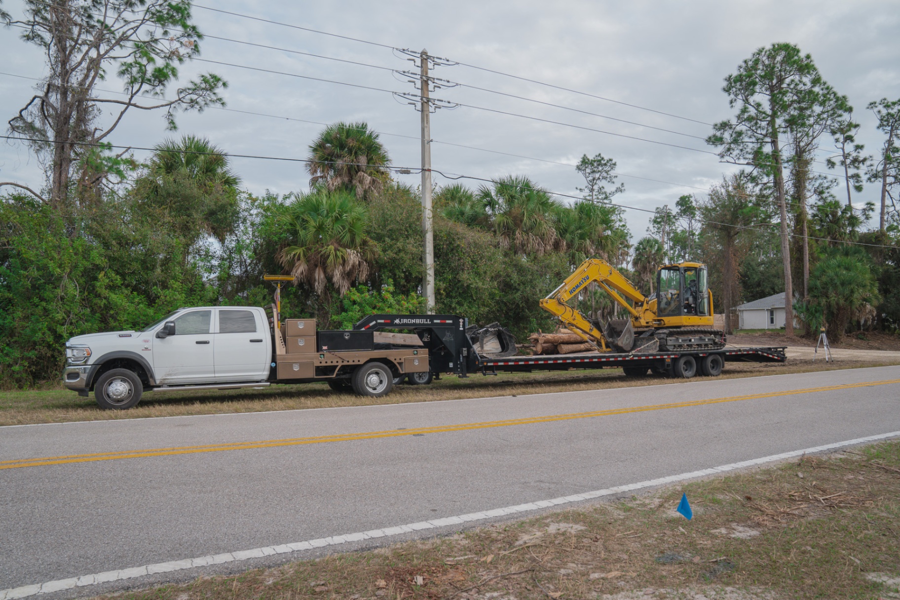 Truck and trailer hauling excavator to job site